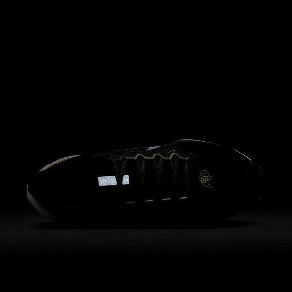 Top view of black Nike running shoe in low-light, showing reflective tongue tab and CU Buffaloes logo on toe